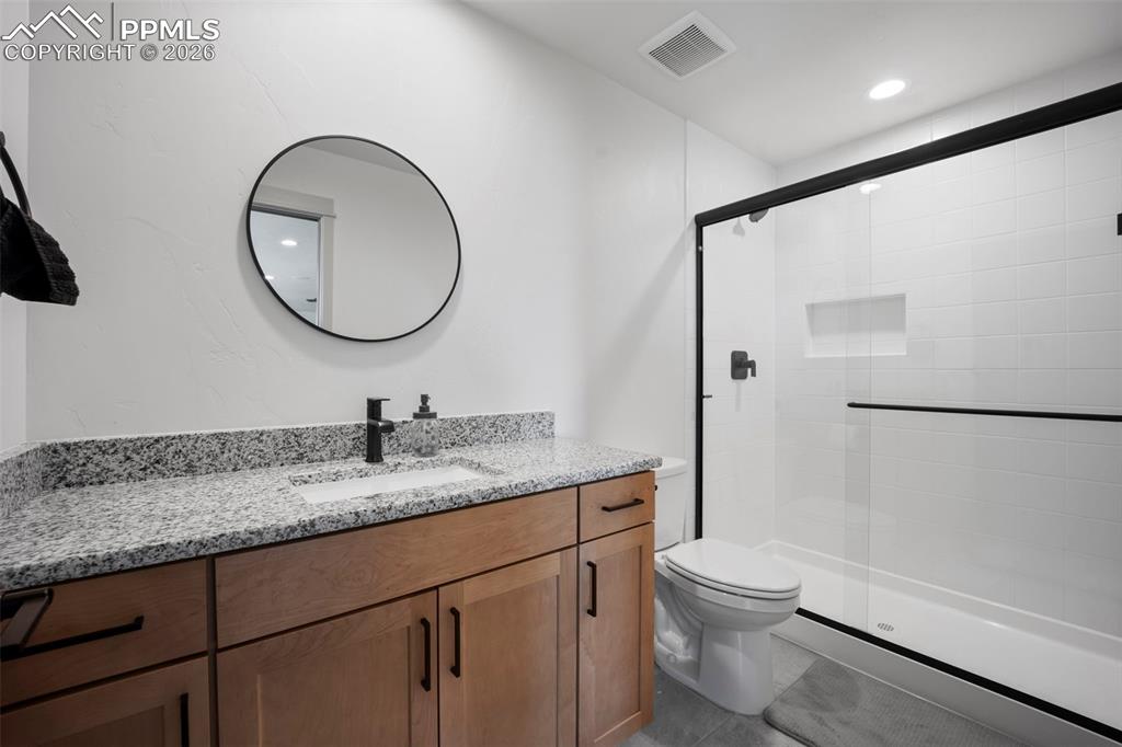 16535 Sweet Road Peyton, CO 80831 - Photo 38 of 45 a bathroom with a granite countertop toilet sink and mirror
