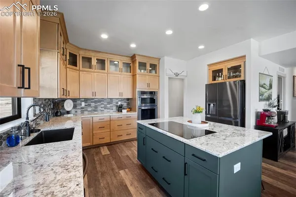 a kitchen with granite countertop a sink stove and refrigerator