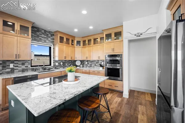 a kitchen with granite countertop a stove refrigerator and microwave