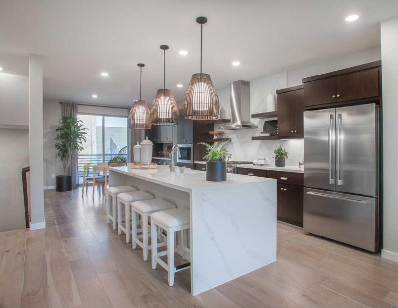 6617 Optimun Loop San Jose, CA 95119 - Photo 4 of 8 a kitchen with stainless steel appliances granite countertop a refrigerator a sink dishwasher a kitchen island with wooden floor and cabinets