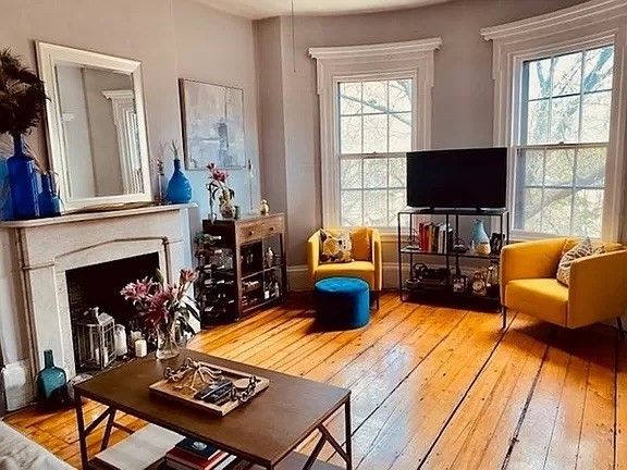 a living room with furniture fireplace and window