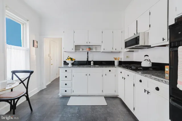a kitchen with granite countertop white cabinets white appliances and granite counter tops