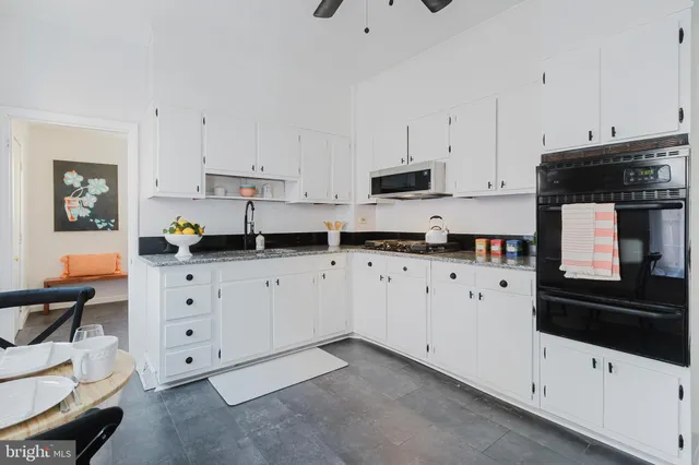 a kitchen with white cabinets and stainless steel appliances