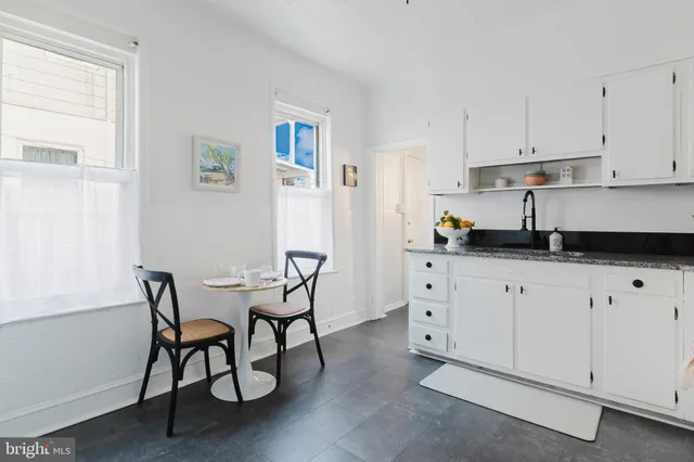 a kitchen with granite countertop white cabinets and white appliances