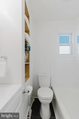 a white toilet sitting next to a shower