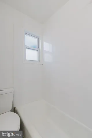 a white toilet sitting next to a shower