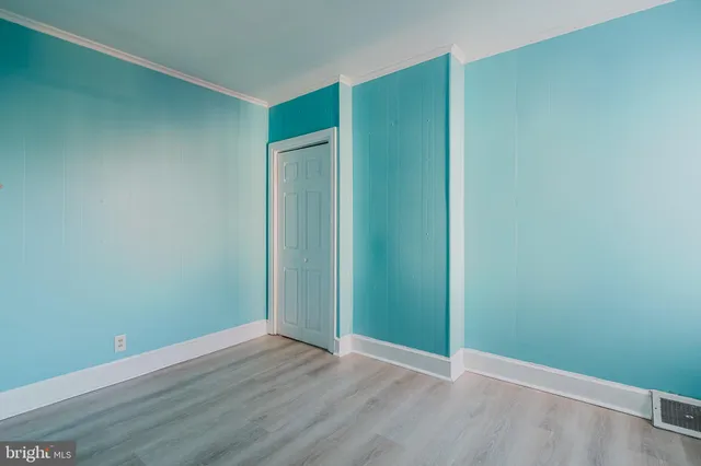 an empty room with wooden floor and closet