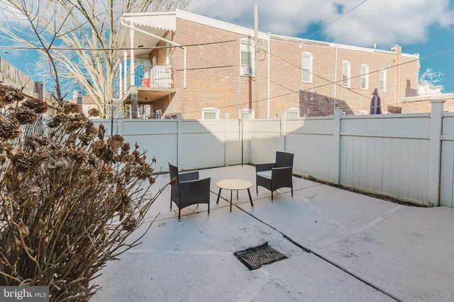 a backyard of a house with table and chairs
