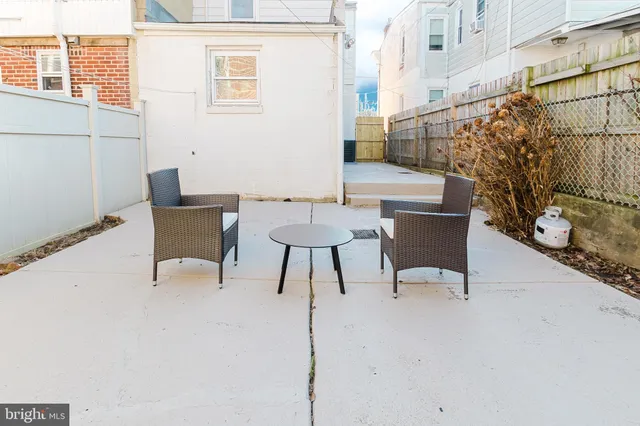 a view of a patio with a table and chairs and potted plants