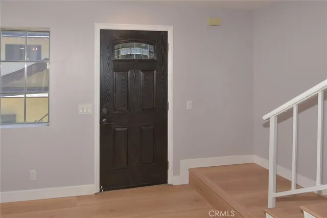 an empty room with windows and fireplace