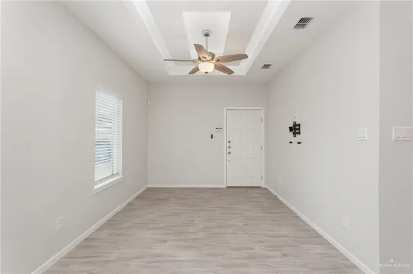 an empty room with windows and fan