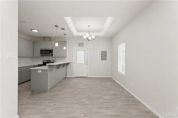 a large white kitchen with kitchen island a sink dishwasher a stove and a refrigerator with wooden floor