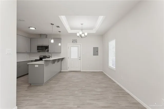 a large white kitchen with kitchen island a sink dishwasher a stove and a refrigerator with wooden floor