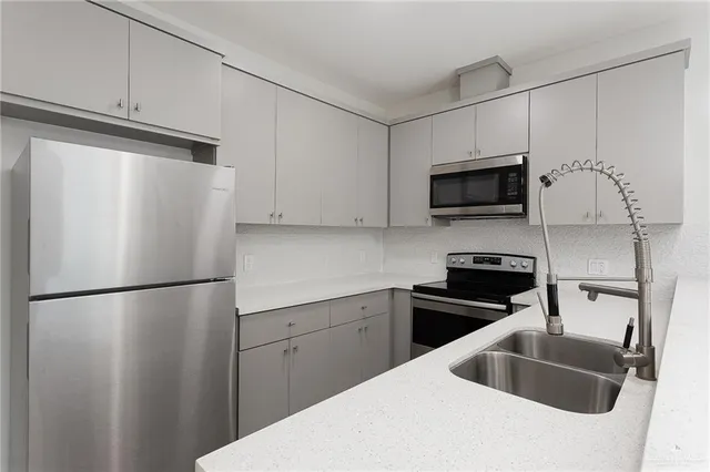 a kitchen with stainless steel appliances a refrigerator sink and microwave