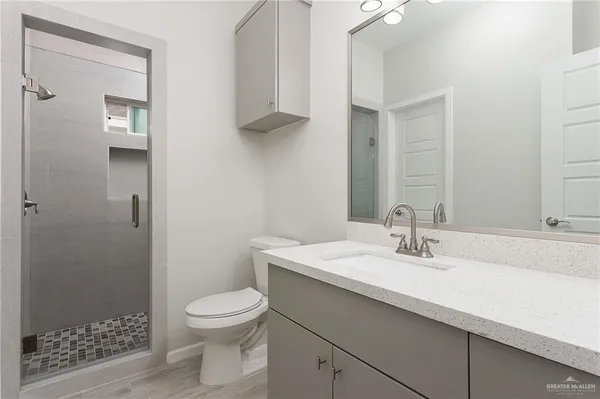 a bathroom with a sink a toilet and shower