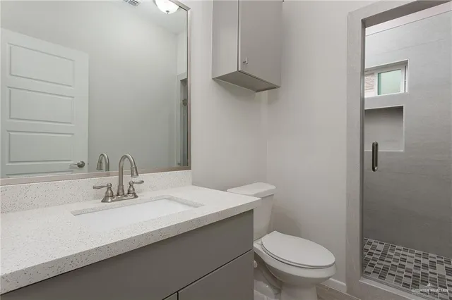 a bathroom with a sink a toilet and shower