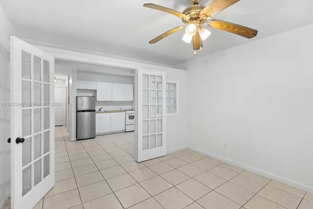 a view of kitchen with white cabinets and refrigerator