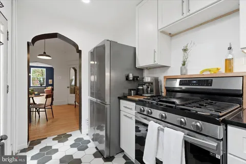 a kitchen with stainless steel appliances granite countertop a stove a refrigerator and a dining table