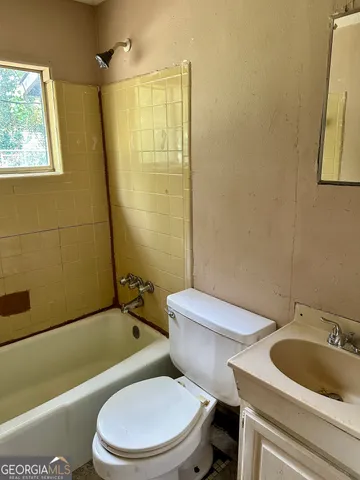 a white toilet sitting next to a bath tub