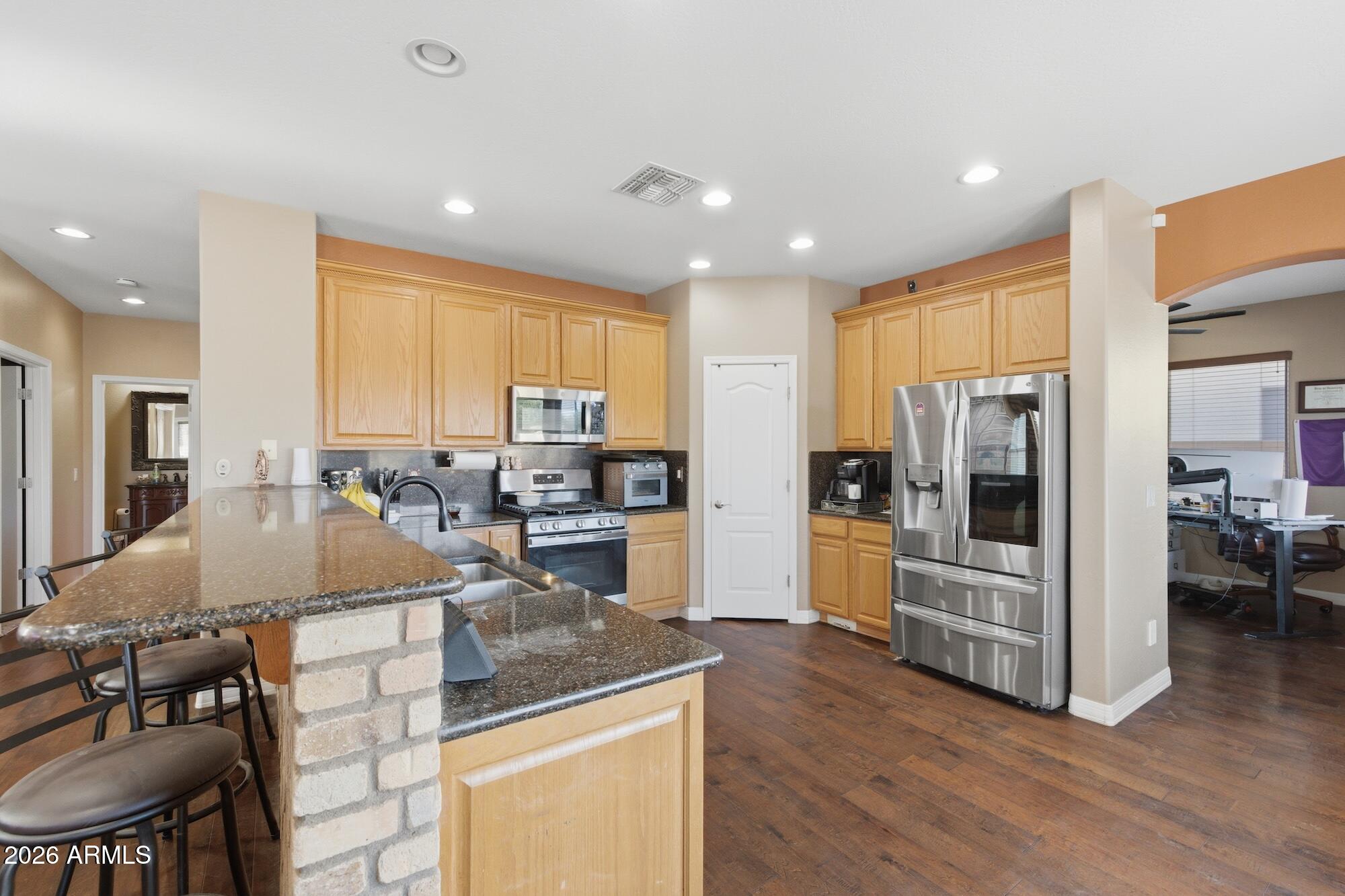 3605 South Danielson Way Chandler, AZ 85286 - Photo 6 of 23 a kitchen with stainless steel appliances granite countertop a refrigerator and stove