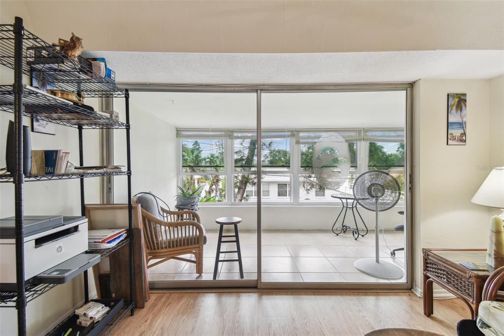 9945 47th Avenue North, Unit 208 St. Petersburg, FL 33708 - Photo 12 of 38 a living room with furniture a flat screen tv and a floor to ceiling window