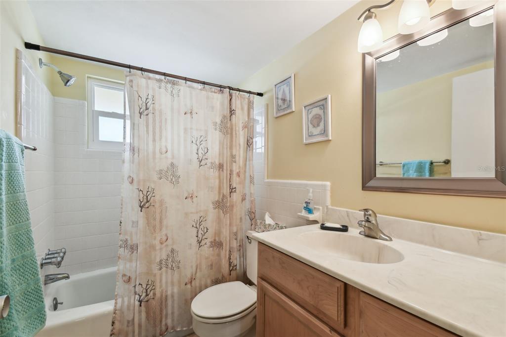 9945 47th Avenue North, Unit 208 St. Petersburg, FL 33708 - Photo 18 of 38 a bathroom with a sink a toilet and shower