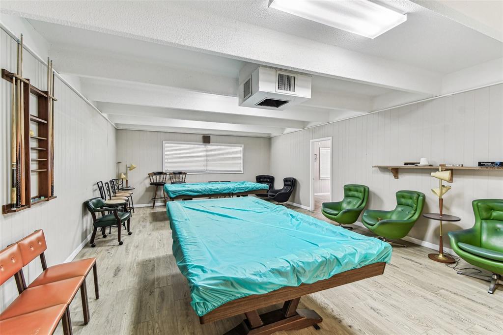 9945 47th Avenue North, Unit 208 St. Petersburg, FL 33708 - Photo 32 of 38 a room with pool table and windows