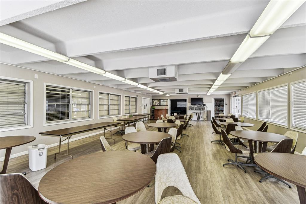 9945 47th Avenue North, Unit 208 St. Petersburg, FL 33708 - Photo 36 of 38 a room with lots of tables a large window and chairs