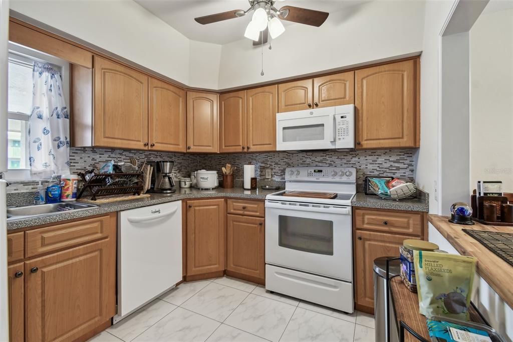 9945 47th Avenue North, Unit 208 St. Petersburg, FL 33708 - Photo 4 of 38 a kitchen with stainless steel appliances granite countertop a stove sink and cabinets