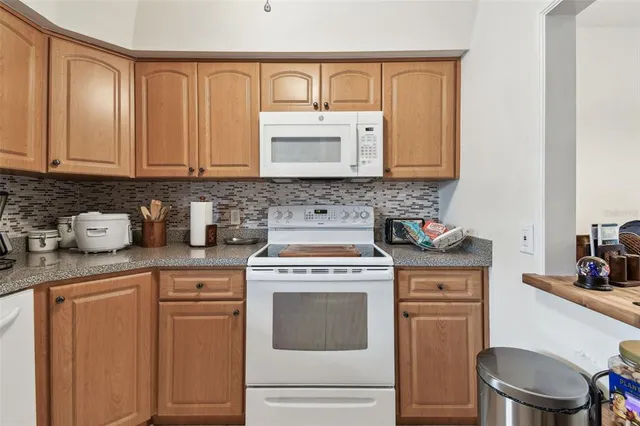 a kitchen with granite countertop a stove sink and cabinets