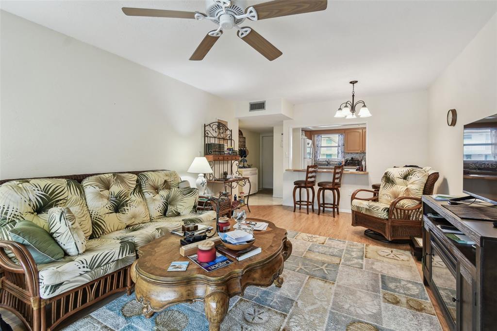 9945 47th Avenue North, Unit 208 St. Petersburg, FL 33708 - Photo 10 of 38 a living room with furniture and a chandelier