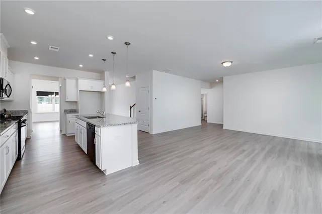 a large kitchen with a table and stainless steel appliances