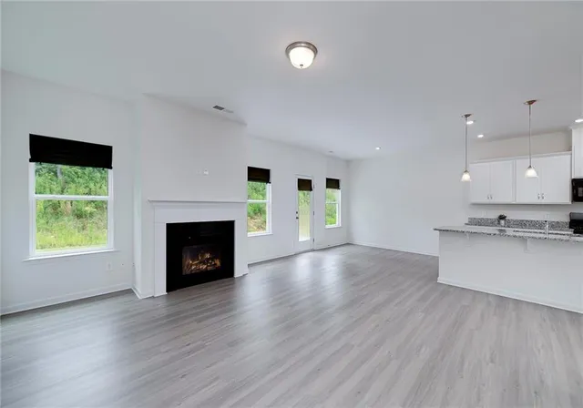 a view of an empty room with a fireplace and a window