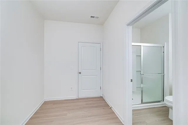 a view of an empty room with wooden floor