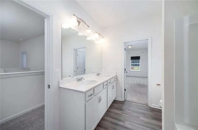 a spacious bathroom with a double vanity sink and mirror