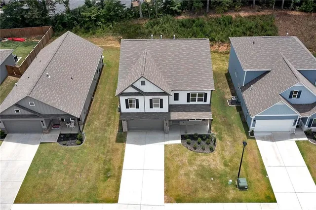 an aerial view of a house with swimming pool and garden