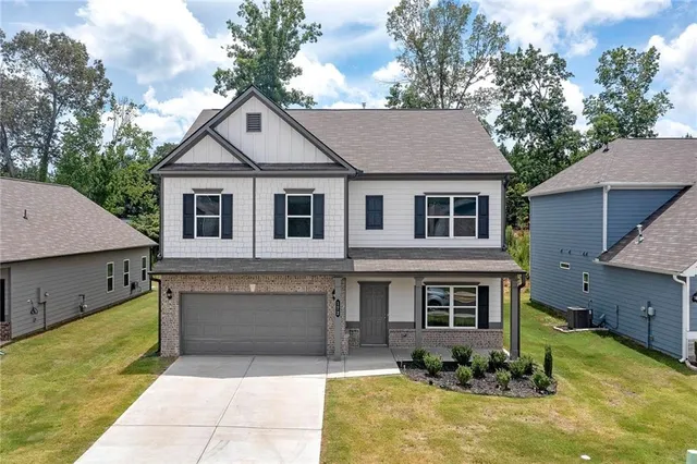 a front view of house with yard garage and trees