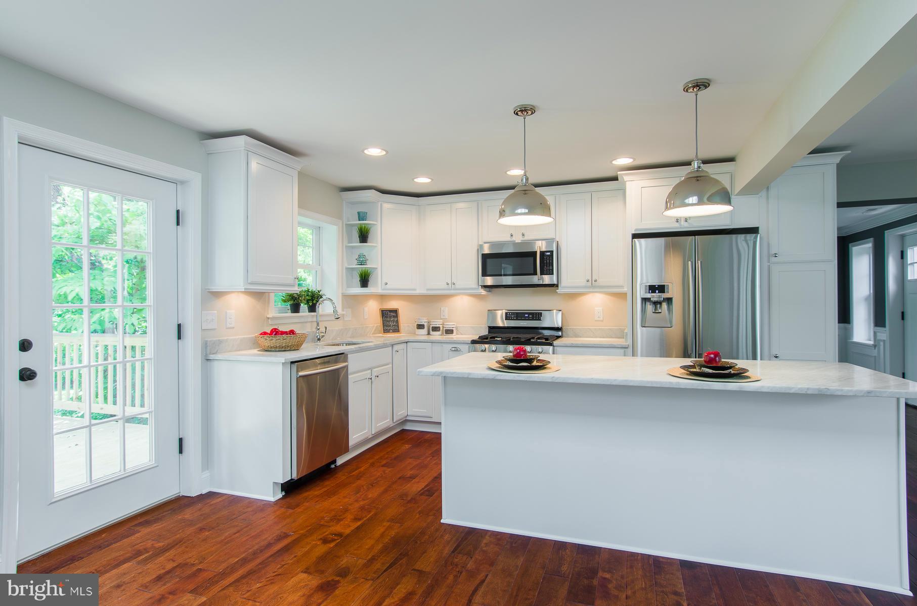 181 Hollen Road Baltimore, MD 21212 - Photo 5 of 30 a kitchen with kitchen island granite countertop a stove a sink a center island and wooden floor
