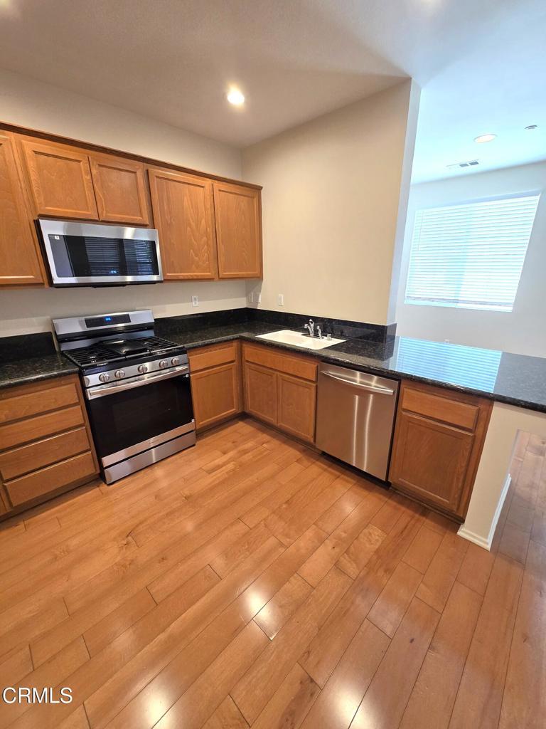 3319 North Ventura Road Oxnard, CA 93036 - Photo 3 of 25 a kitchen with stainless steel appliances granite countertop a stove a sink and a microwave