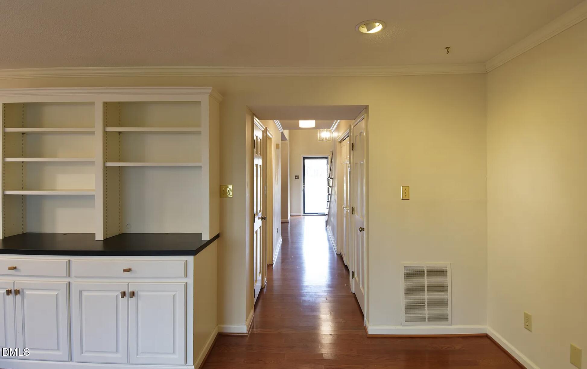 6403 Andsley Drive Raleigh, NC 27609 - Photo 5 of 21 a view of a hallway with wooden floor and cabinet
