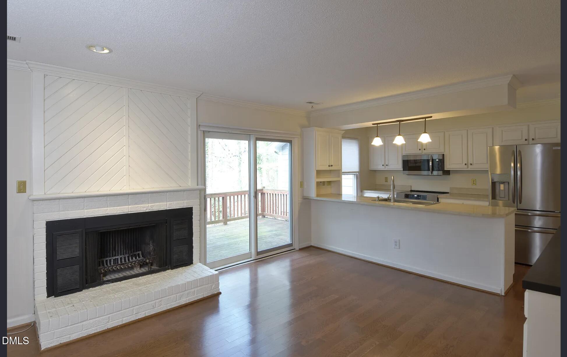 6403 Andsley Drive Raleigh, NC 27609 - Photo 7 of 21 a large white kitchen with a stove a refrigerator and a fireplace
