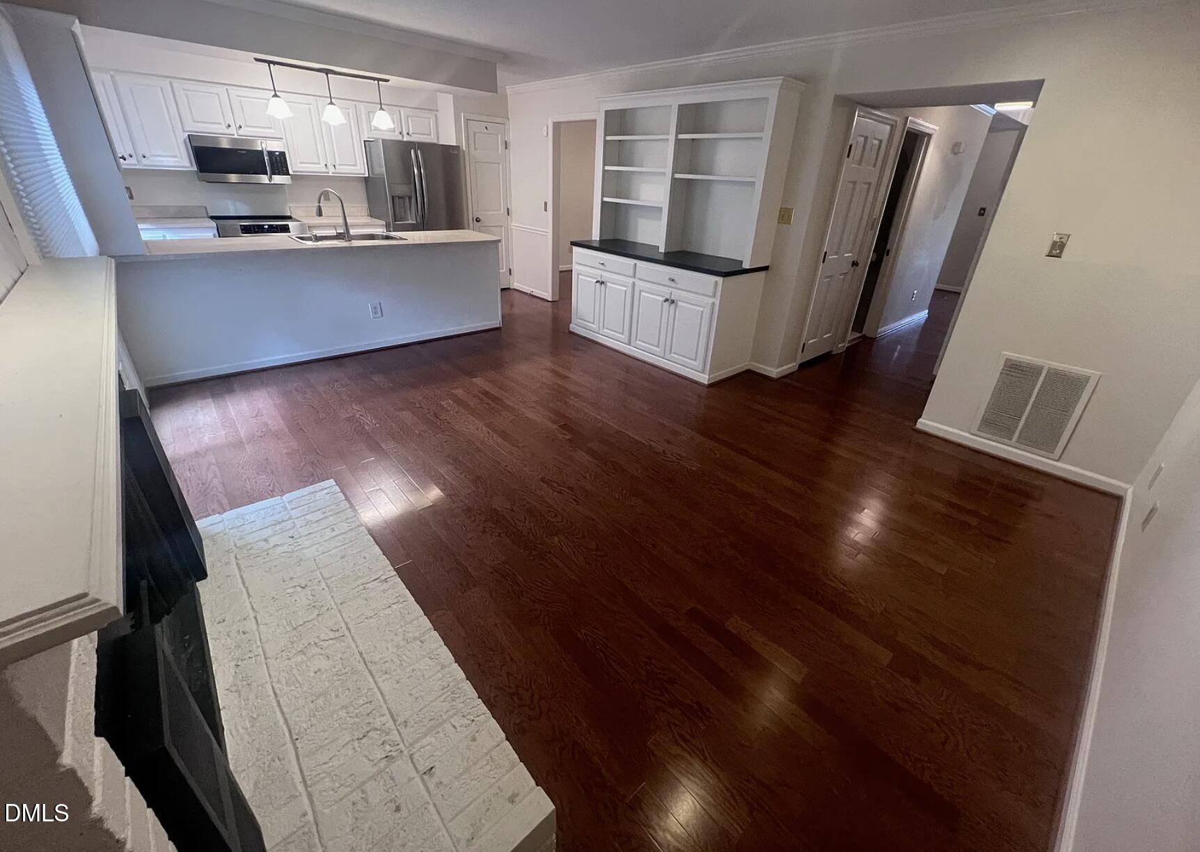 6403 Andsley Drive Raleigh, NC 27609 - Photo 10 of 21 a kitchen with stainless steel appliances kitchen island granite countertop a refrigerator a sink and wooden floors