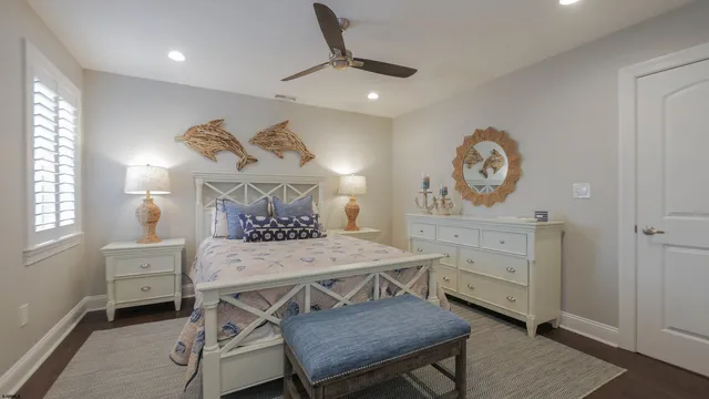 a bedroom with a bed a chandelier and a dresser