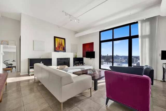a living room with fireplace furniture and a large window