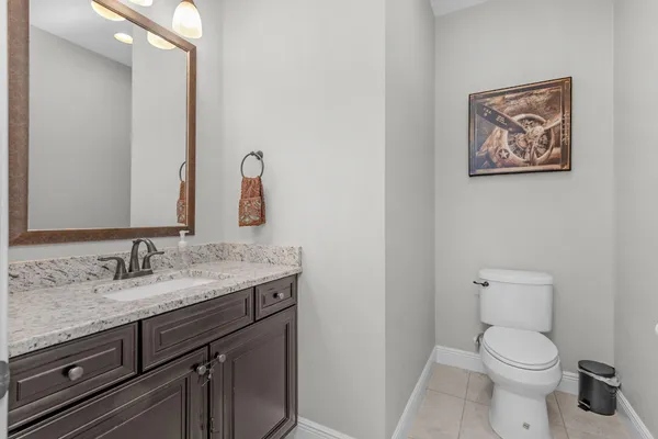 a bathroom with a granite countertop toilet sink and mirror