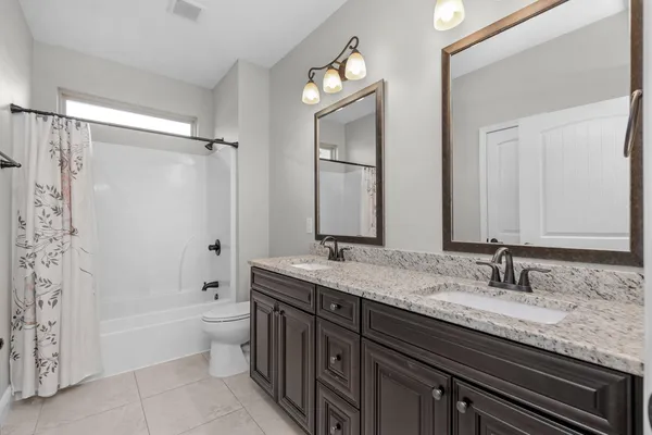 a bathroom with a granite countertop sink a toilet and bathtub
