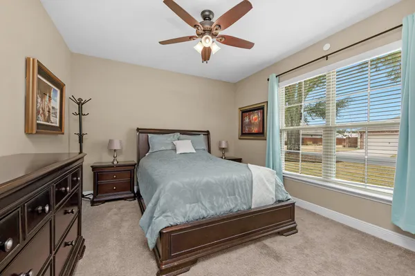 a bedroom with a bed and a large window with a projector