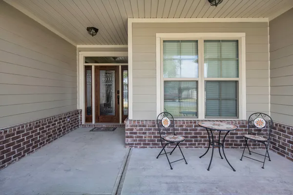 a view of porch with a table and chairs