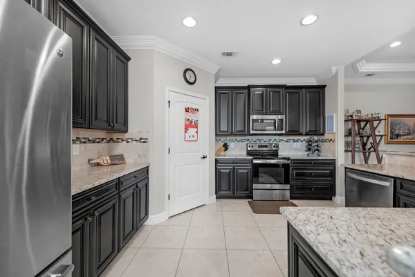 a kitchen with kitchen island granite countertop a stove sink and cabinets