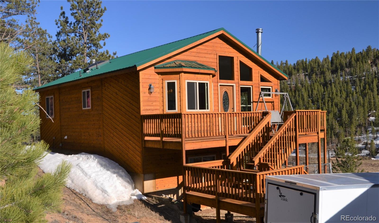 627 North Random Road Bailey, CO 80421 - Photo 3 of 15 a front view of a house with wooden stairs